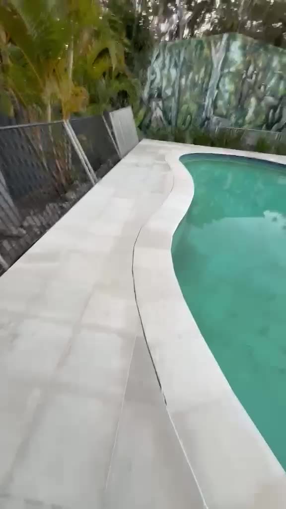Freeform pool with a light stone paved surround